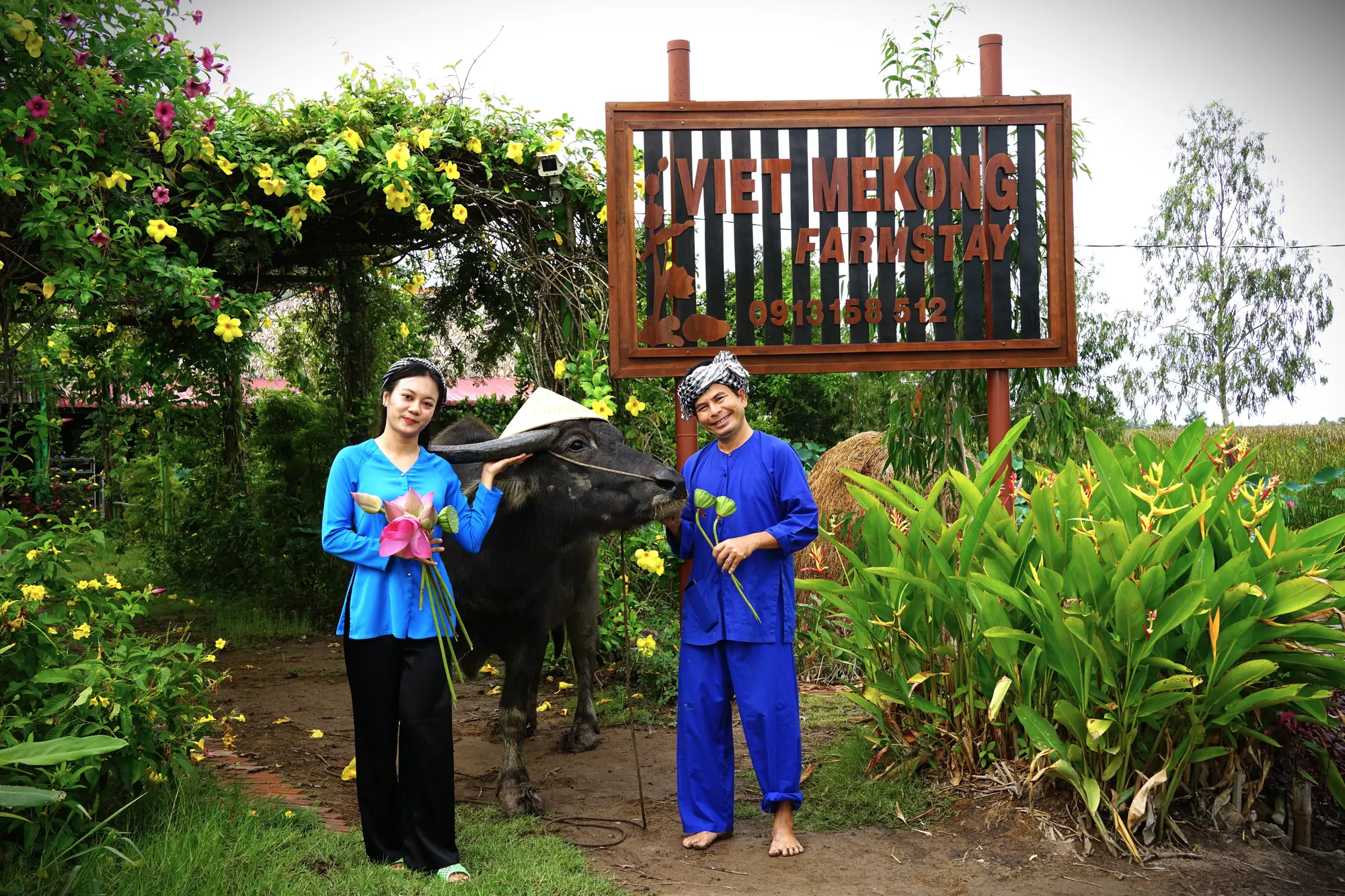 Local hosts beside a water buffalo at Việt Mekong Farmstay