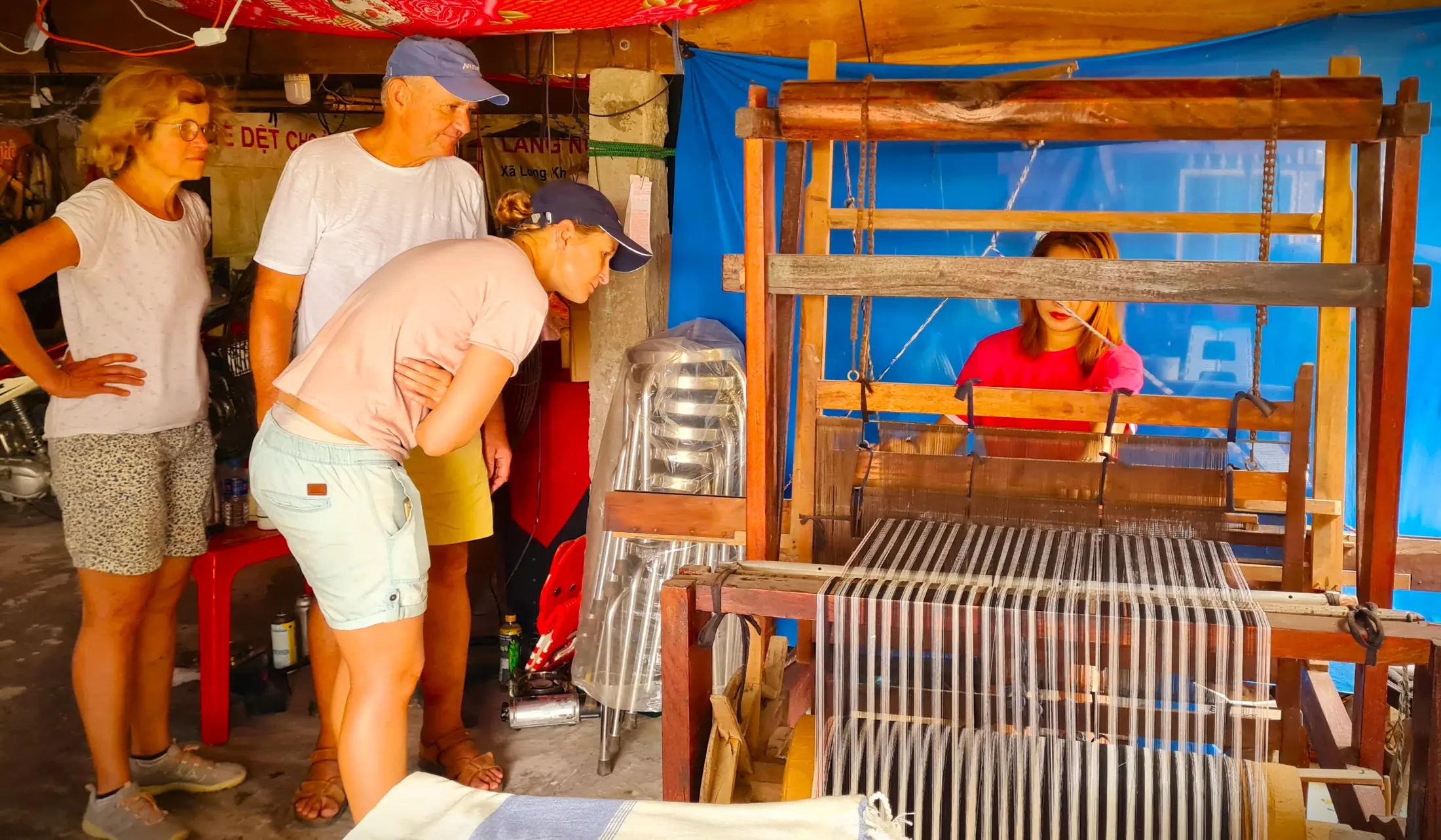 Visitors observing traditional textile weaving in a Dong Thap craft village