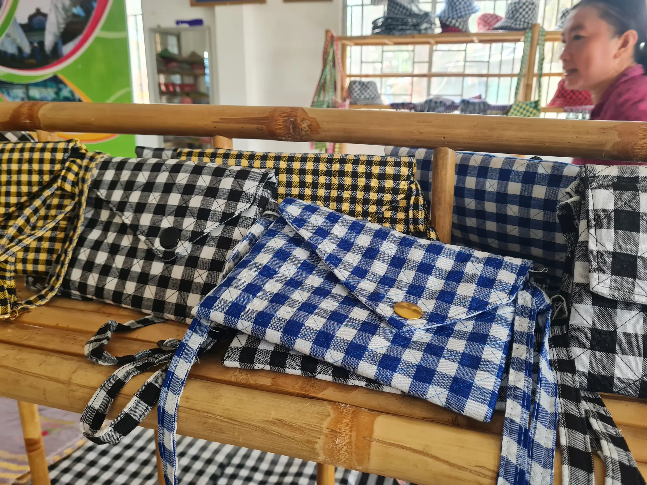 Finished black-and-white checkered scarves displayed beside a loom