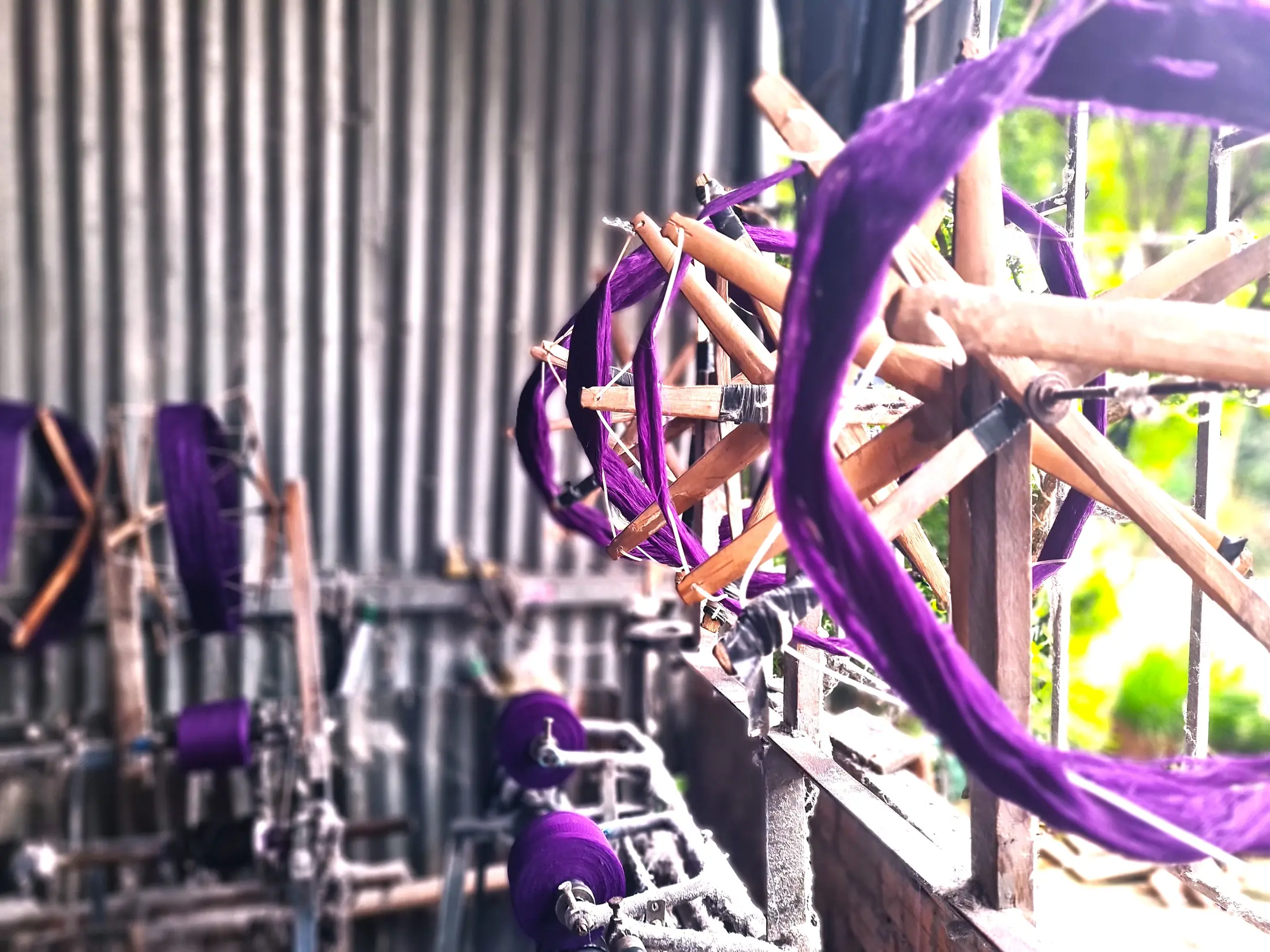 Purple threads moving through part of a traditional loom