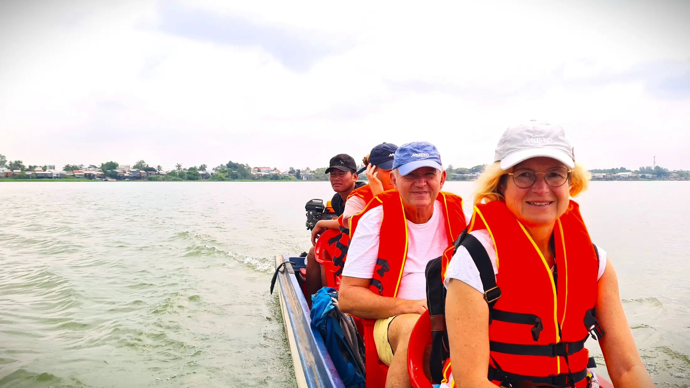 International visitors wearing life jackets on a Mekong River boat